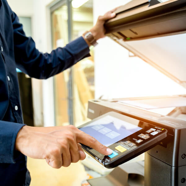 An employee uses a multifunction copier and printer